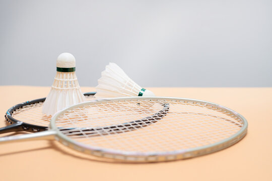 Badminton Rackets and Shuttlecocks on Peach Background
