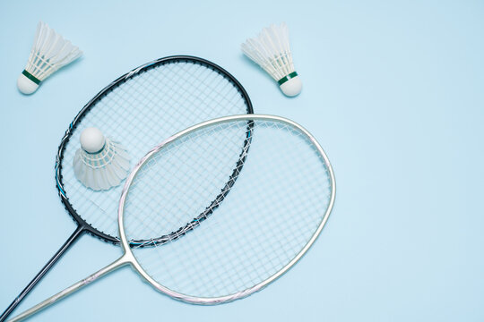 Top View of Badminton Rackets and Shuttlecocks on Light Blue Background