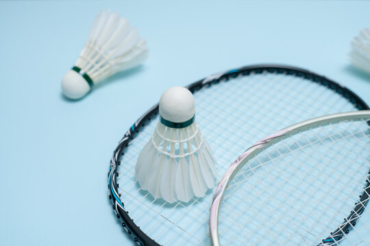 Close-up of Badminton Rackets and Shuttlecocks on Light Blue Background