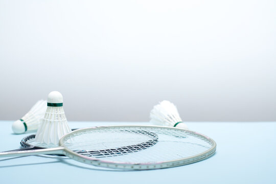 Badminton Rackets and Shuttlecocks on Light Blue Background