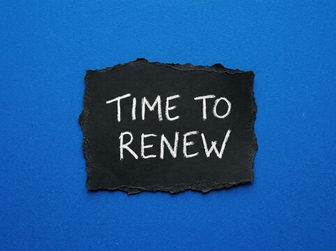 Black Torn Paper with "Time to Renew" Written in Chalk, Blue Background, Renewal Concept