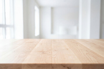 Naklejka premium Empty wooden table surface with blurred white room background for product display