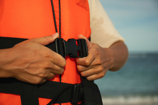 Individual secures life jacket before engaging in water activities