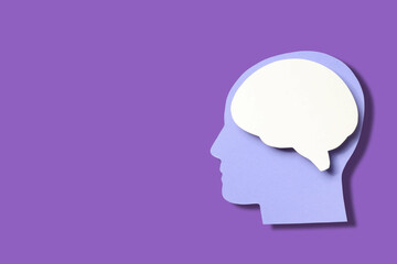 Fototapeta premium Purple backdrop shows paper cutout of head and brain
