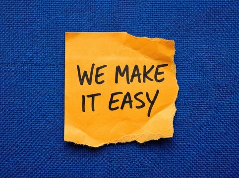 Torn Orange Sticky Note with "WE MAKE IT EASY" Text, Against Textured Blue Background, Simplicity Concept