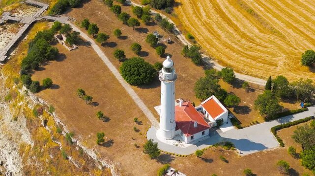 Seddulbahir, Eceabat, Turkey. Mehmetcik Feneri lighthouse, white cylindrical tower with red roofs, aerial close-up over Cape Helles where the Dardanelles meets the Aegean Sea. Aerial View, MasterShot