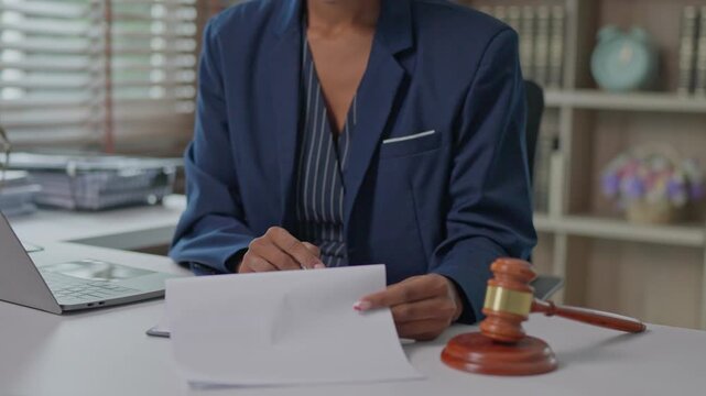 Female lawyer signing legal contract at desk