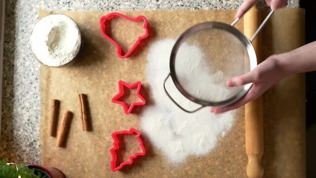 Sifting flour through sieve onto baking paper