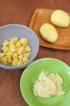 Fresh raw diced chopped and mashed potatoes variant on wooden table