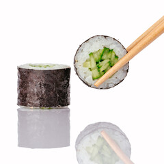 Chopsticks picking up a fresh cucumber maki roll © Cavan