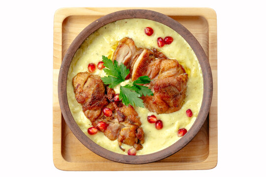 Georgian shkmeruli chicken dish on white background