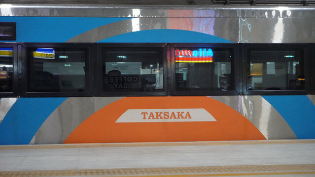 Purwokerto, Indonesia - 6 June 2026: Side view of the Taksaka passenger train with colorful blue and orange livery parked at a station platform.