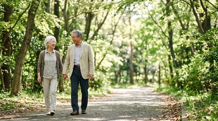 Fototapeta premium 新緑の公園を笑顔で散歩するシニア夫婦