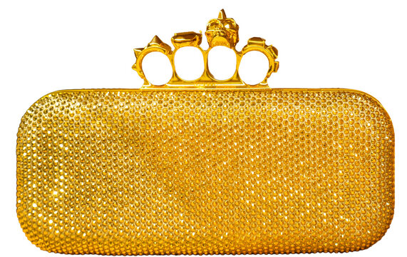 Four Ring. A clutch bag with a brass knuckle-shaped handle, in gold and covered in crystals, by the British luxury brand Alexander McQueen