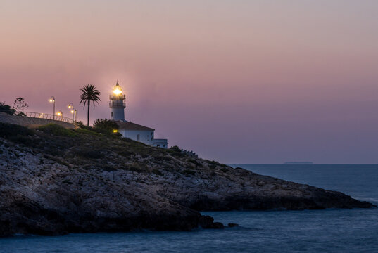 Mediterranean landscapes. Cullera lighthouse lit at dusk.