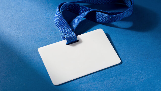 Blank white identification badge with blue lanyard on textured blue background, copy space for text, perfect for event access, corporate branding and security passes