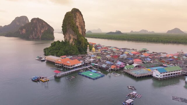 Scenic aerial overview with 360-degree Video of Koh Panyi (Koh Panyee) fishing village featuring stilt houses, a Muslim mosque, and a floating soccer pitch nestled among limestone karsts in Phang Nga 