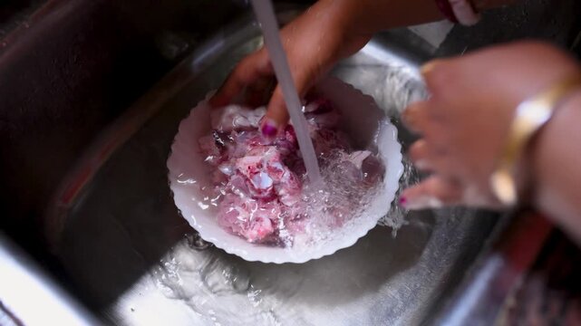 An Indian married woman hygienically washing fresh raw mutton in a kitchen basin before cooking. Close-up of clean red meat preparation, traditional home cooking, food safety, healthy meal preparation