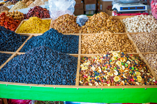 Traditional market display featuring premium raisins, dried apricots, walnuts, almonds, pistachios, mixed nuts, trail mix, and assorted dried fruits at the famous Chorsu Bazaar in Tashkent, Uzbekistan