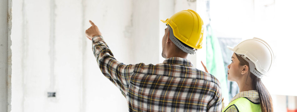 Asian contractor and engineer inspecting material in construction building.