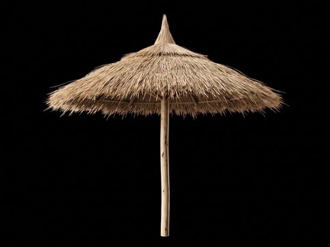 A thatched straw beach umbrella with a natural wooden pole isolated against a solid black background