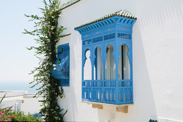 Fototapeta premium White Building with Blue Shutters and Bougainvillea in Mediterranean Town