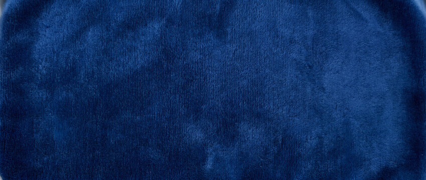 Velvet texture background presenting a rich navy blue fabric surface with soft vertical grain and gentle sheen across a plush luxurious backdrop