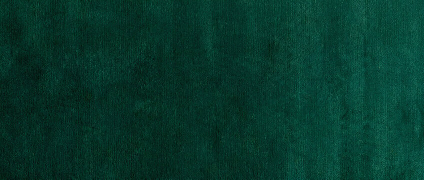 Fur texture background exhibiting a rich emerald green animal coat with fine silky strands and gentle waves across a plush surface