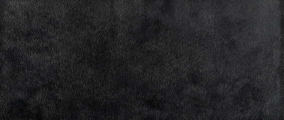 Fototapeta premium Gray textured wall reveals a smooth dark matte surface with soft even brushstrokes and subtle neutral undertones