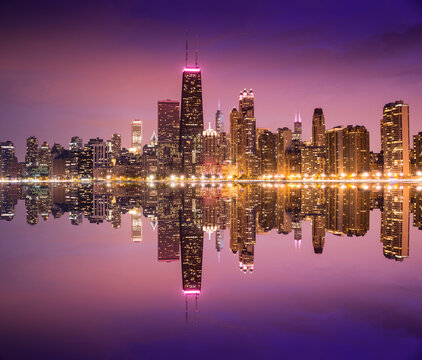 Chicago skyline illuminated at twilight across Lake Michigan