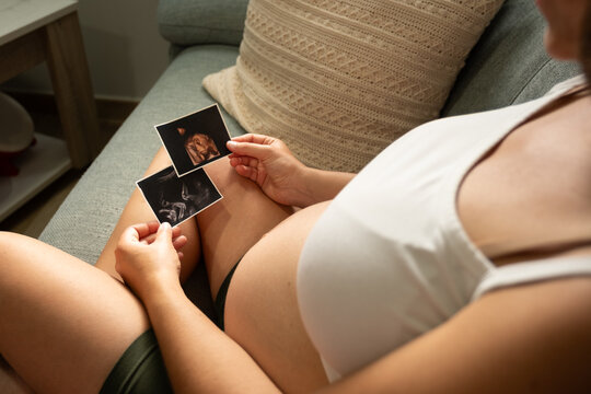 Expecting mother looking at baby ultrasound photos