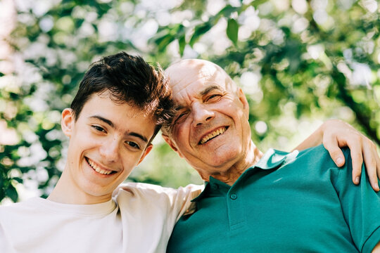 Happy grandfather and grandson posing together outdoors