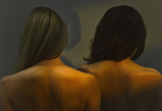 Backs of two women with blonde and brown hair