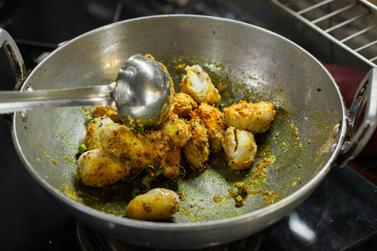 Indian style taro root curry being cooked in a wok