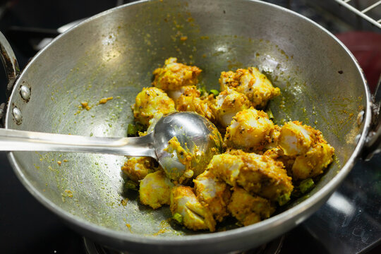 Indian style taro root curry being cooked in a wok