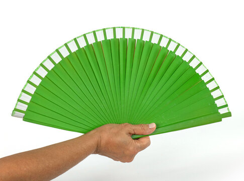 Ventaglio verde tenuto in mano su sfondo bianco scontornato