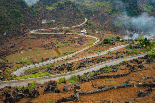 Scenic Mountain Road Curving Through Agricultural Fields and Rocky Terrain of Vietnam's Ha Giand Loop - horizontal