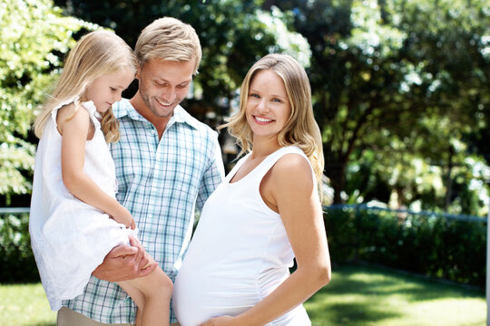 Smile, father and child in nature with pregnant woman, love and summer holiday for bonding together. Portrait, parents and happy at park with daughter, maternity and weekend break for family vacation