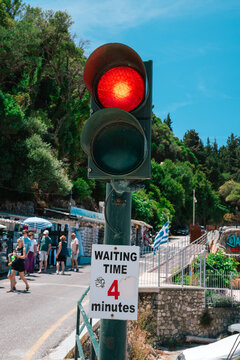 Red traffic light with waiting time sign on a Greek coastal road