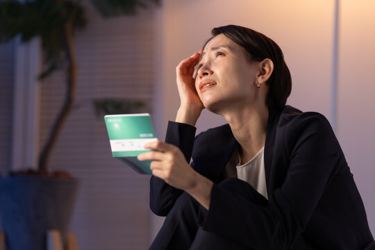 通帳を見る女性