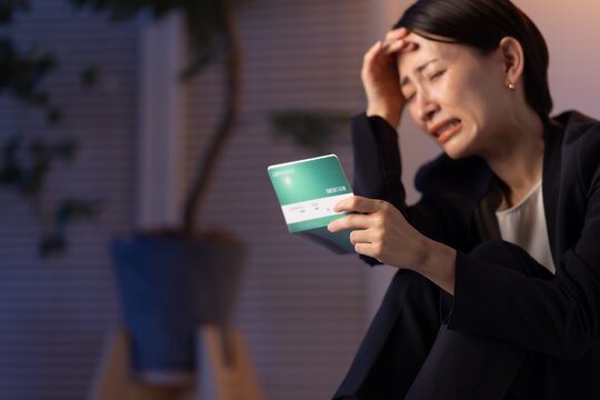 通帳を見る女性