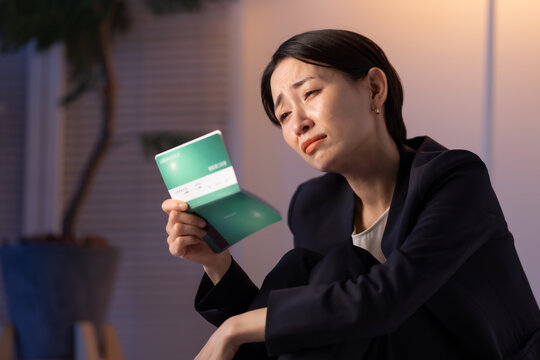 通帳を見る女性