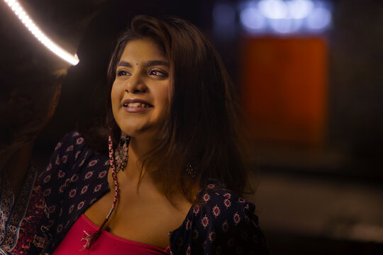 Portrait of beautiful woman standing on street at night