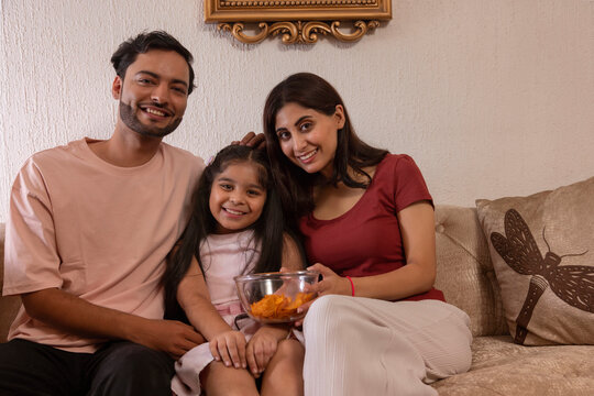 Happy young couple spending good time together with their daughter at home