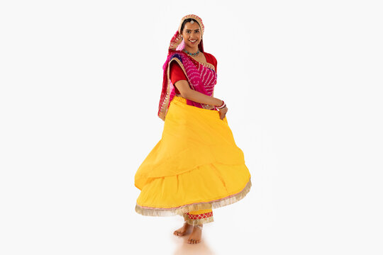 Portrait of Rajasthani woman dancing against white background