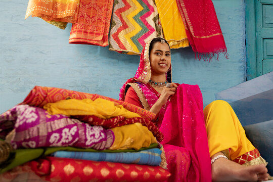  Rajasthani woman selling colourful local fabrics outside her house in Rajasthan