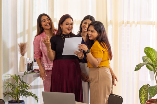 Group of business colleagues reviewing documents at meeting in modern office