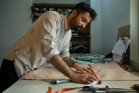 Fashion designer measuring the width of the cloth 