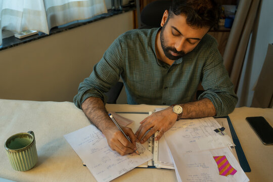 A young professional working on clothing designs in his studio 