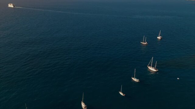 Aerial view of sailboats anchored in Atlantic Ocean, Drone shot of yachts on calm blue sea with coastal travel scenery 4k